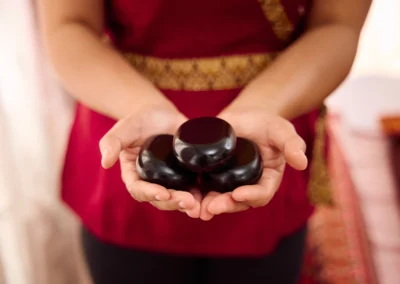 3 Massagesteine in offenen Händen für die Hot Stone Massage