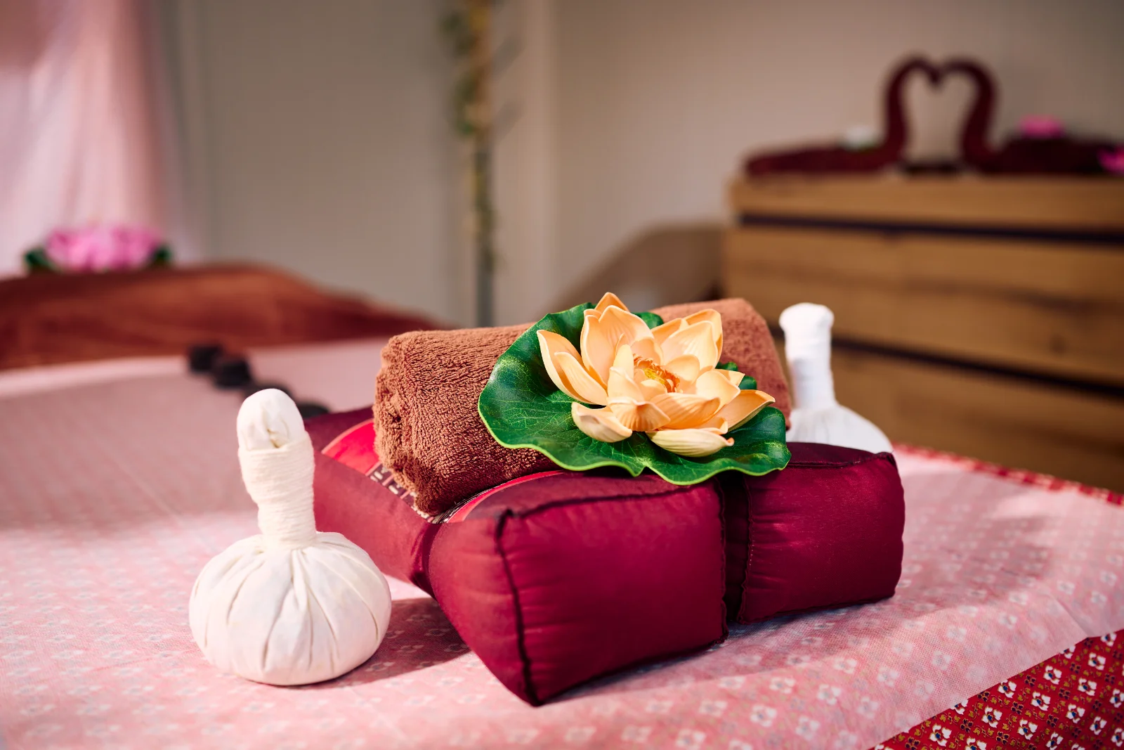 MOI Wellness- & Thai-Massagen Impression Stilleben - Kissen, kräuterstempel, Handtuch, Lotusblüte